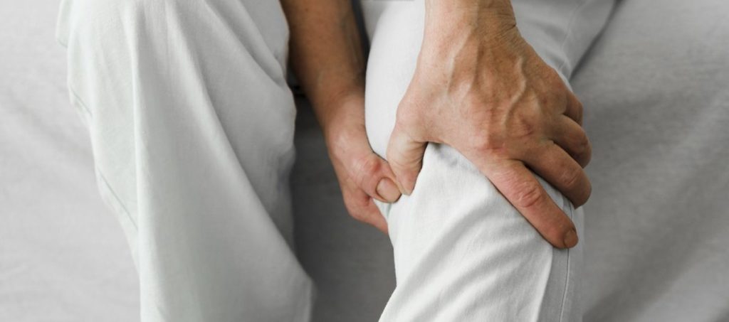 Persona anziana che si tocca ginocchio dolorante